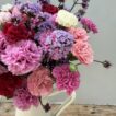 A vase full of Scented Pinks and Verbena in a white tin jug