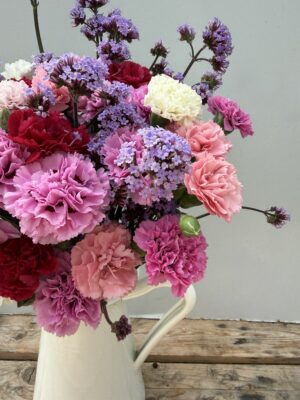 A vase full of Scented Pinks and Verbena in a white tin jug